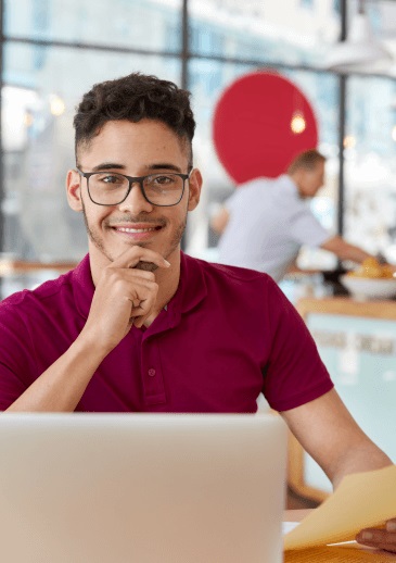 Photo d'un travailleur souillant et content devant son ordinateur